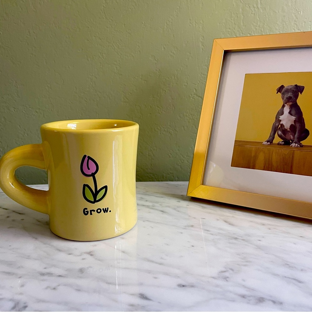 Yellow Life is Good Mug. Yellow with pink tulip that says “Grow”on it.